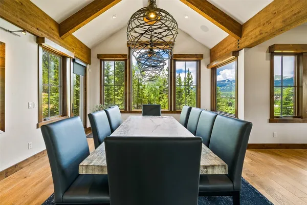 a view of a dining room with furniture a chandelier and wooden floor