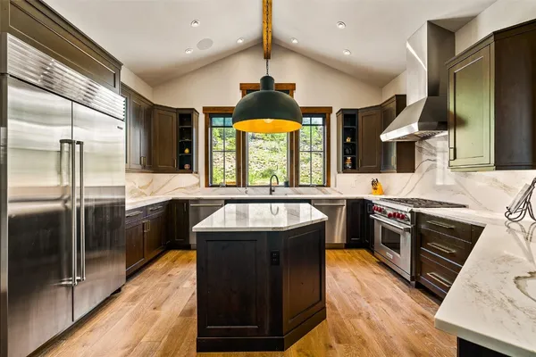 a large kitchen with stainless steel appliances granite countertop a sink and a stove