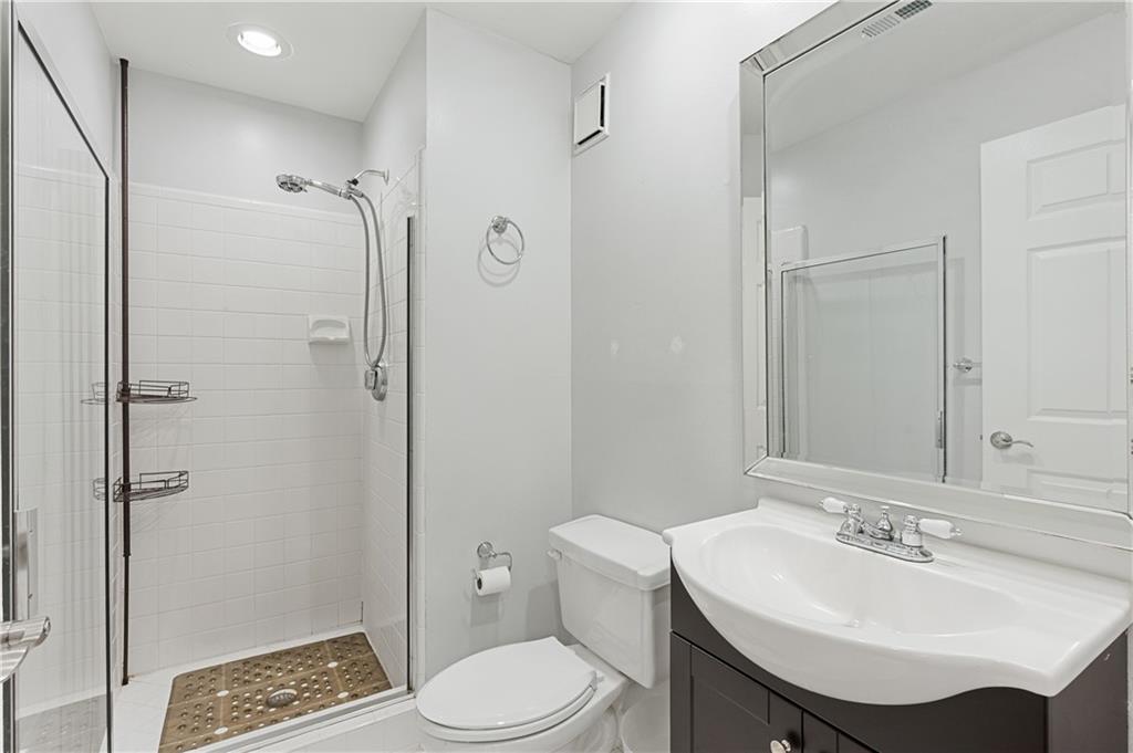 220 Renaissance Parkway Northeast, Unit 2119 Atlanta, GA 30308 - Photo 13 of 19 a bathroom with a sink toilet and shower
