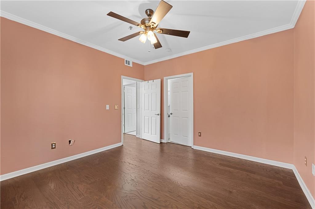 220 Renaissance Parkway Northeast, Unit 2119 Atlanta, GA 30308 - Photo 14 of 19 an empty room with wooden floor and ceiling fan