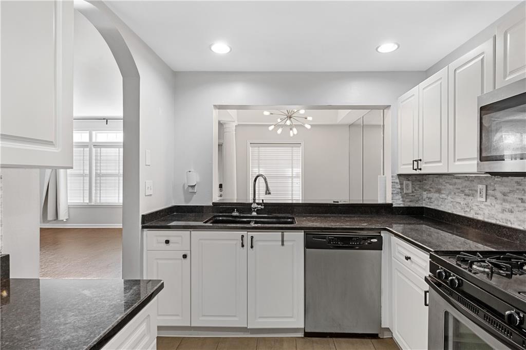 220 Renaissance Parkway Northeast, Unit 2119 Atlanta, GA 30308 - Photo 3 of 19 a kitchen with granite countertop a sink and cabinets