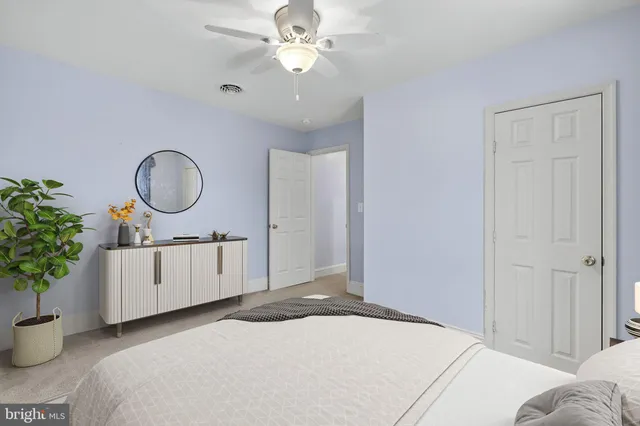 a bedroom with a bed a chandelier and a mirror