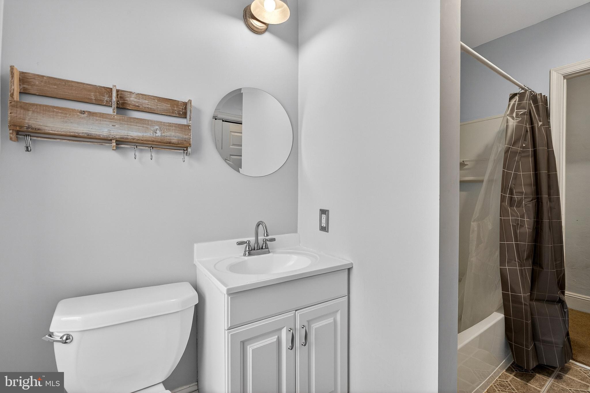 110 West Camden Wyoming Avenue Wyoming, DE 19934 - Photo 14 of 32 a bathroom with a toilet sink and mirror