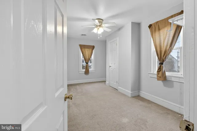an empty room with window and hardwood floor