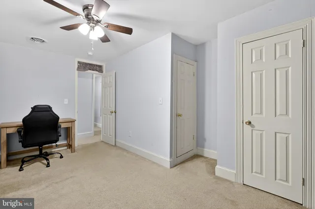 a view of a workspace with furniture and a window