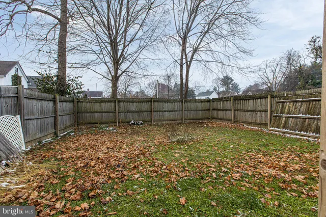 a view of backyard with wooden fence