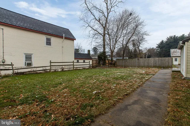 a view of backyard with wooden fence