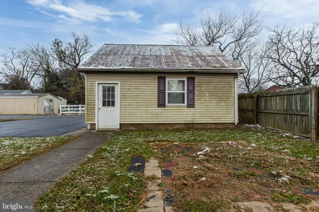 a front view of a house with a large tree