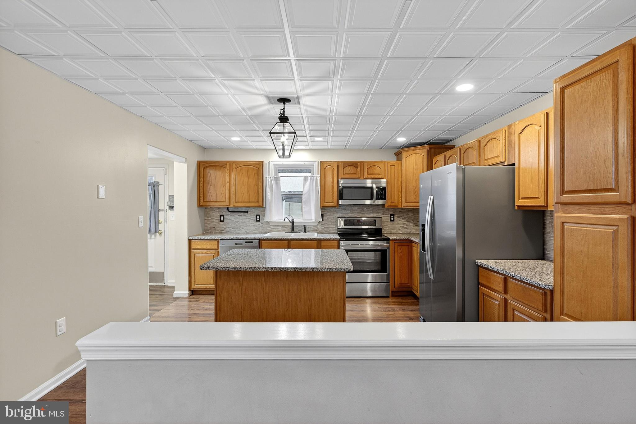 110 West Camden Wyoming Avenue Wyoming, DE 19934 - Photo 5 of 32 a kitchen with stainless steel appliances kitchen island granite countertop a refrigerator a stove top oven a sink and dishwasher