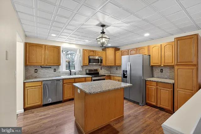 a kitchen with refrigerator cabinets and wooden floor