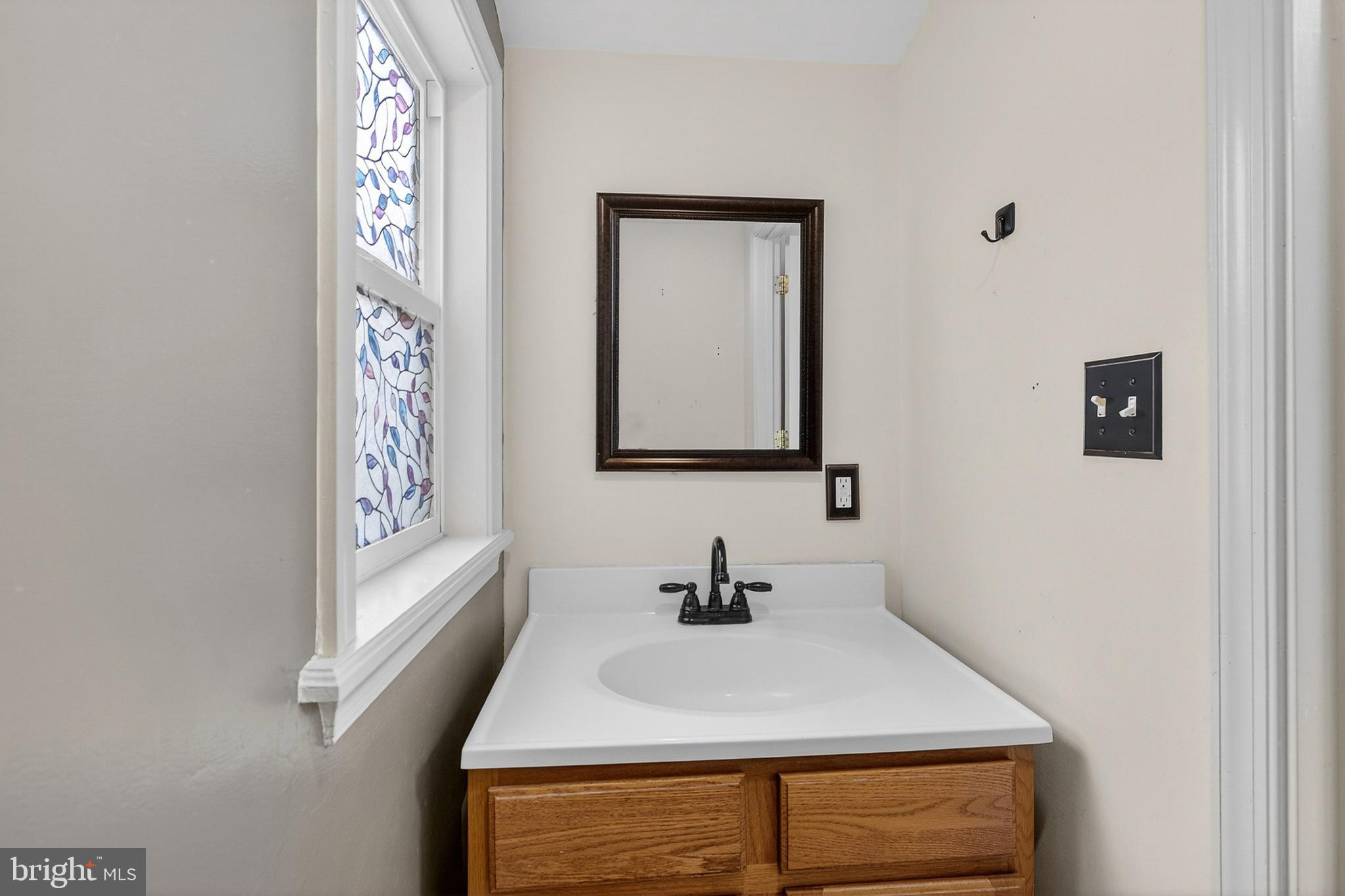 110 West Camden Wyoming Avenue Wyoming, DE 19934 - Photo 9 of 32 a bathroom with a sink and a mirror