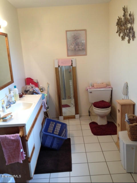 922 Clearlake Road Cocoa, FL 32922 - Photo 13 of 31 a bathroom with a sink a toilet and a mirror