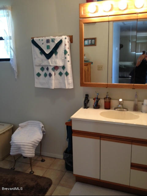 922 Clearlake Road Cocoa, FL 32922 - Photo 17 of 31 a bathroom with a sink a mirror and a toilet
