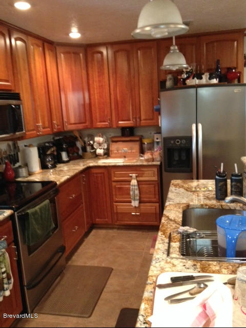 922 Clearlake Road Cocoa, FL 32922 - Photo 22 of 31 a kitchen with stainless steel appliances granite countertop a stove a sink and a microwave