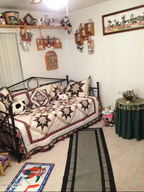 922 Clearlake Road Cocoa, FL 32922 - Photo 23 of 31 a bed sitting in a bedroom next to a lamp on a rug