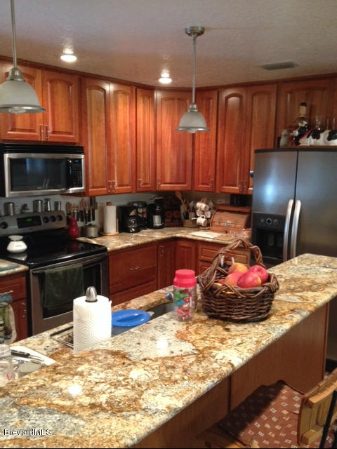 922 Clearlake Road Cocoa, FL 32922 - Photo 4 of 31 a kitchen with kitchen island granite countertop a sink a stove and a microwave