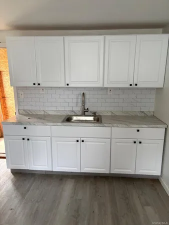 a kitchen with granite countertop white cabinets and white appliances