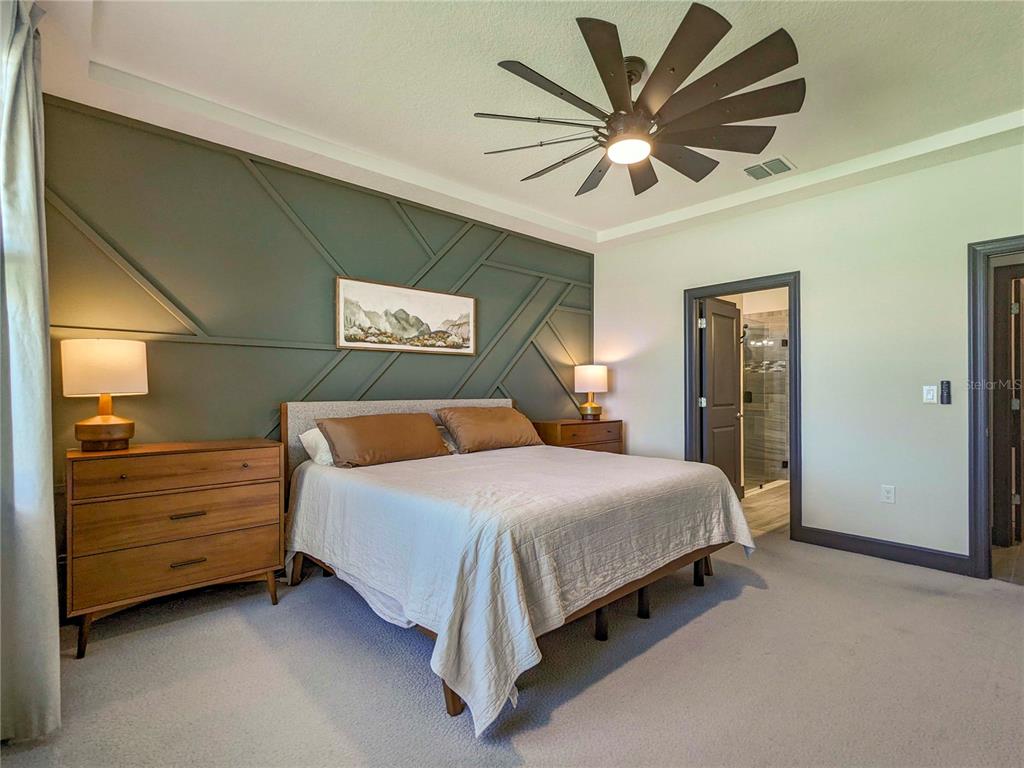 3324 Big Sky Way Lakewood Ranch, FL 34211 - Photo 11 of 49 a spacious bedroom with a bed and a ceiling fan