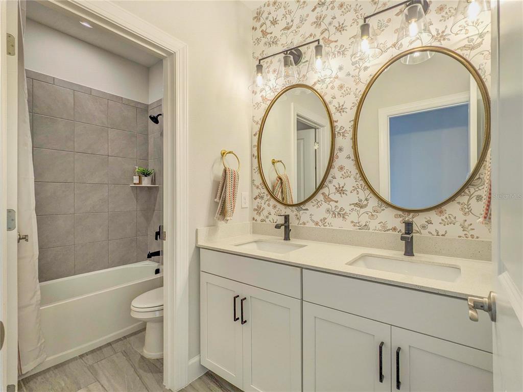 3324 Big Sky Way Lakewood Ranch, FL 34211 - Photo 31 of 49 a bathroom with a granite countertop toilet a sink a mirror and bathtub