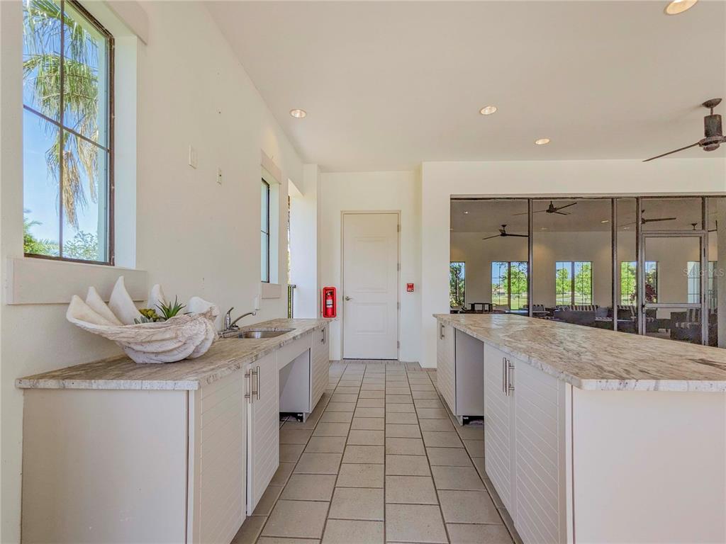 3324 Big Sky Way Lakewood Ranch, FL 34211 - Photo 44 of 49 a large white kitchen with granite countertop a sink and dishwasher a stove with wooden cabinets