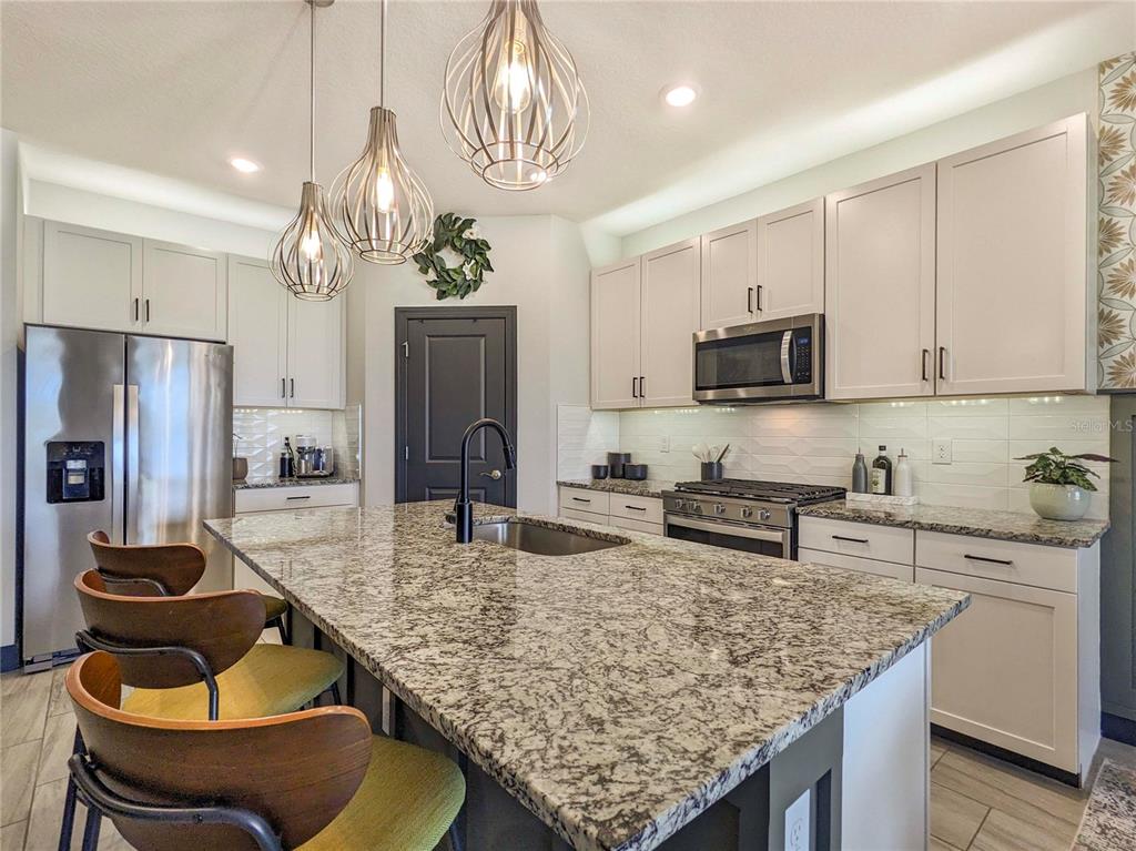 3324 Big Sky Way Lakewood Ranch, FL 34211 - Photo 6 of 49 a kitchen with stainless steel appliances granite countertop a sink refrigerator and microwave
