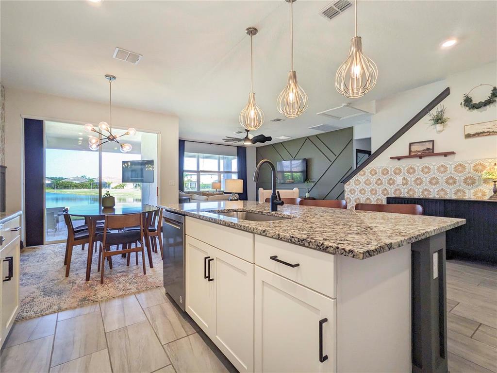 3324 Big Sky Way Lakewood Ranch, FL 34211 - Photo 7 of 49 a kitchen with center island table and chairs in it