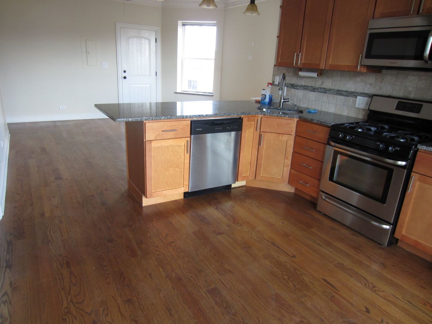 2117 West Irving Park Road, Unit 3R Chicago, IL 60618 - Photo 2 of 10 a kitchen with stainless steel appliances granite countertop a stove a sink and a microwave