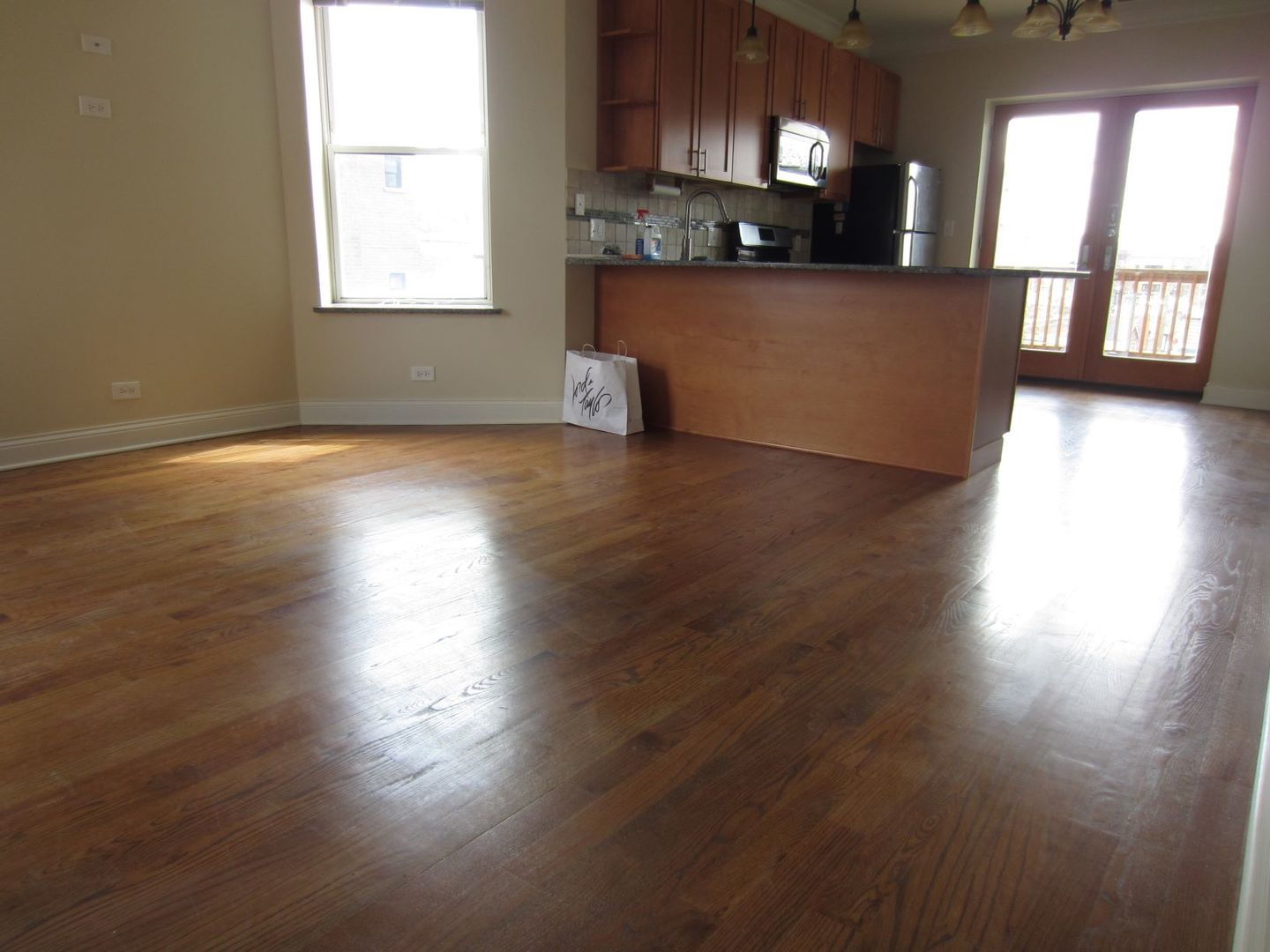 2117 West Irving Park Road, Unit 3R Chicago, IL 60618 - Photo 3 of 10 a view of a kitchen with cabinets wooden floor and a window