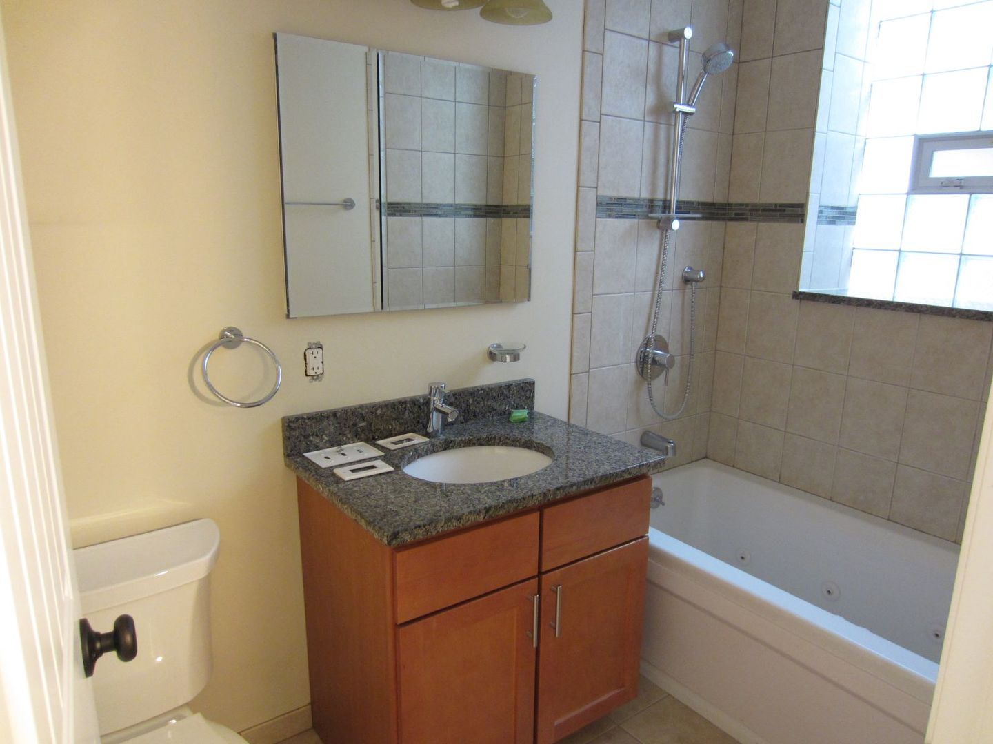2117 West Irving Park Road, Unit 3R Chicago, IL 60618 - Photo 7 of 10 a bathroom with a granite countertop sink a mirror and shower