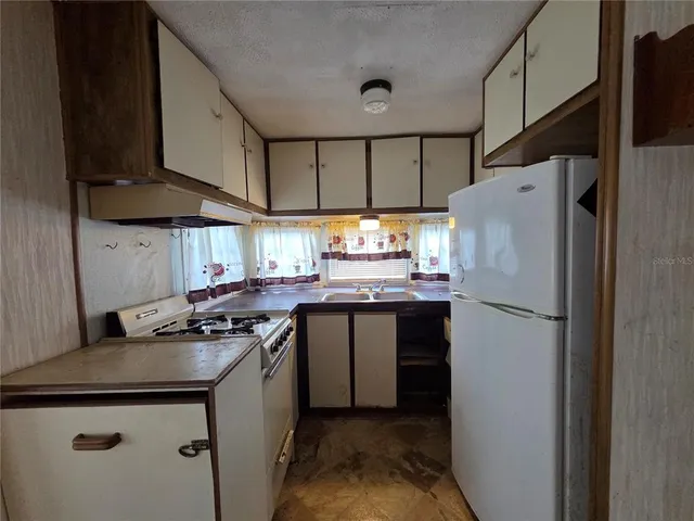 a view of empty room with window and refrigerator