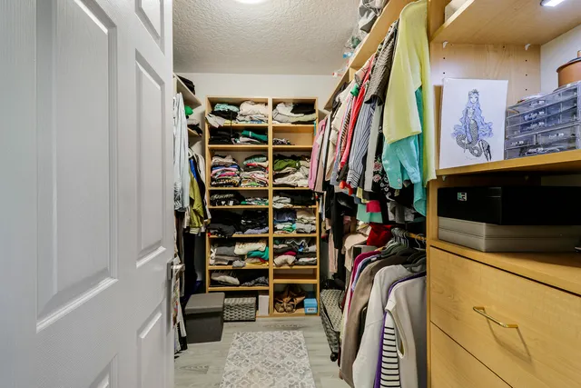 a view of walk in closet with clothes and shoes