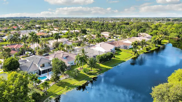 an aerial view of a city with lots of residential buildings ocean and mountain view in back
