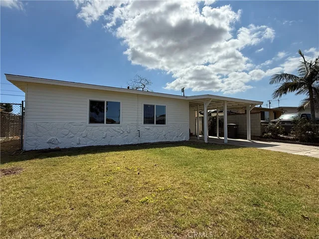 a view of a house with a backyard and a tree