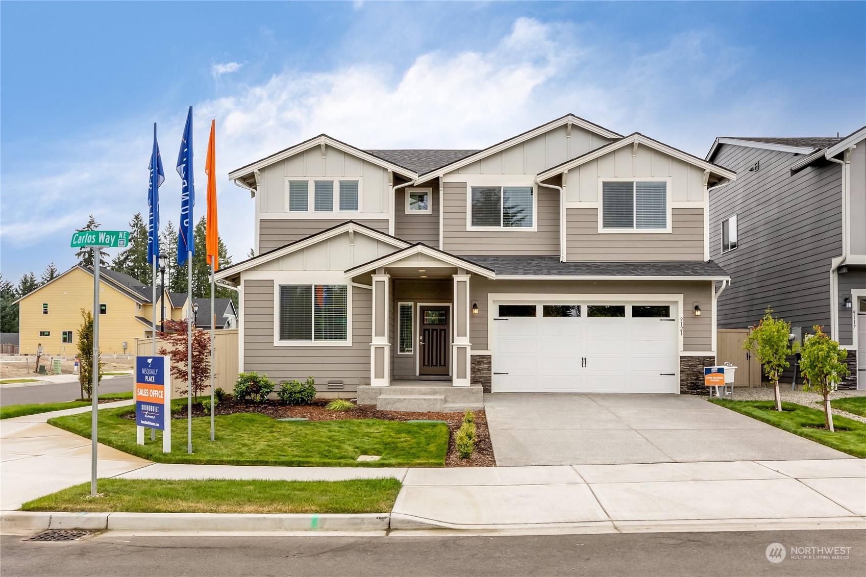 a view of a white house with large windows and plants