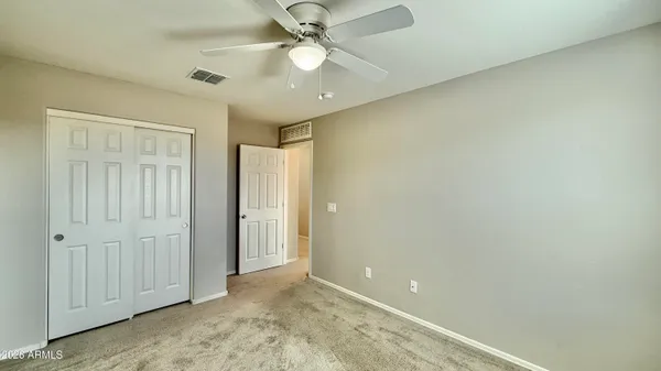 an empty room with a ceiling fan and a window