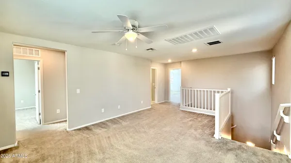an empty room with a ceiling fan and window