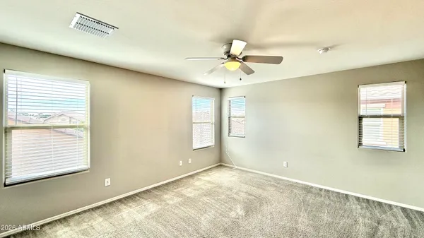 a view of empty room with window and ceiling fan