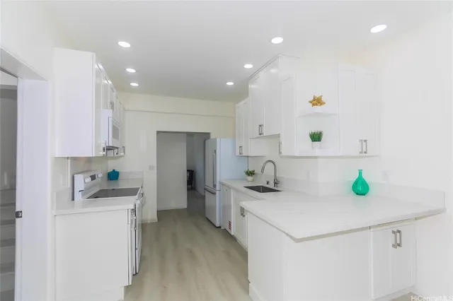a kitchen that has a sink cabinets and wooden floor