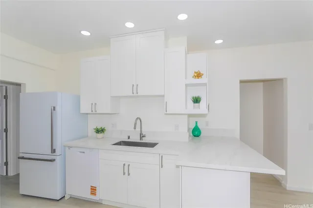 a kitchen with a sink a refrigerator and cabinets