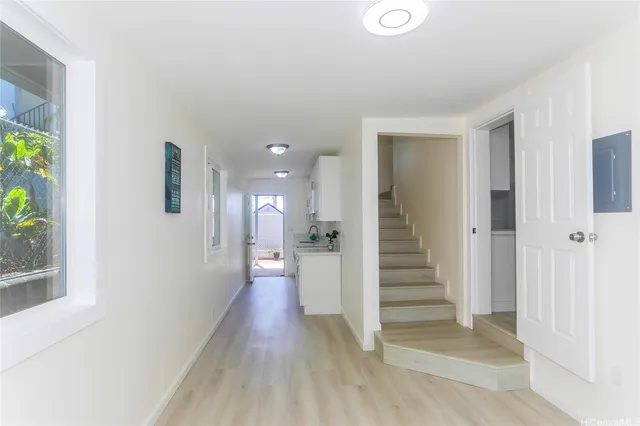 a view of a hallway with stairs and wooden floor