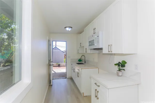 a kitchen with white cabinets and appliances