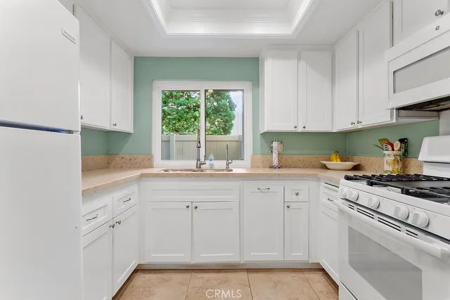 a kitchen with white cabinets and white appliances