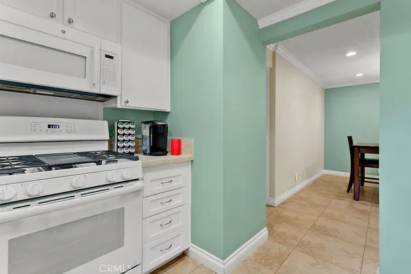 a kitchen with granite countertop white cabinets and appliances