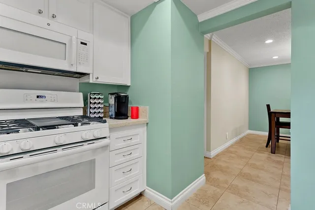 a kitchen with granite countertop white cabinets and appliances
