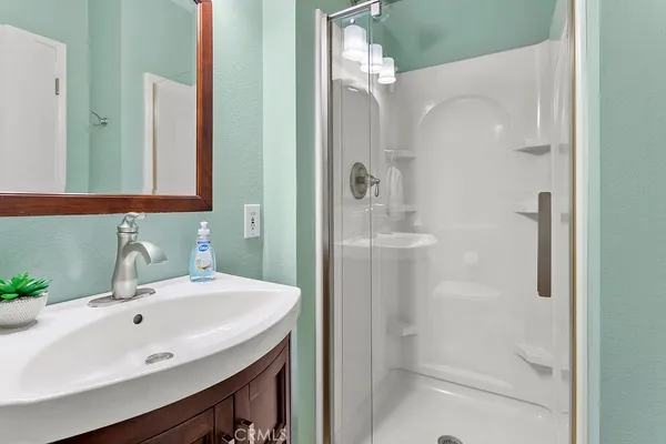a bathroom with a sink a shower and a mirror