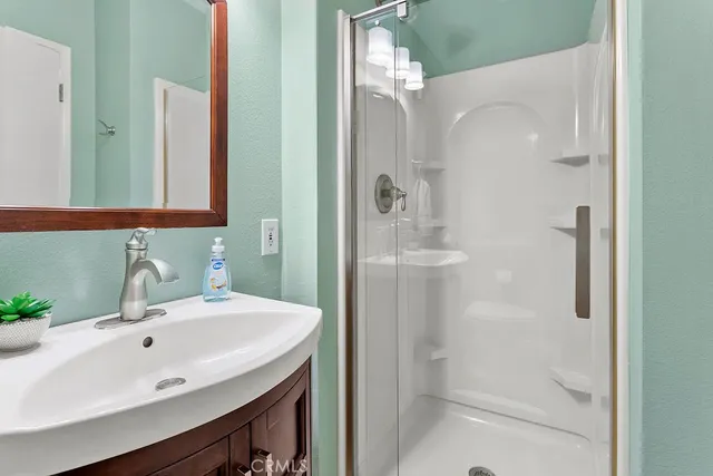 a bathroom with a sink a shower and a mirror