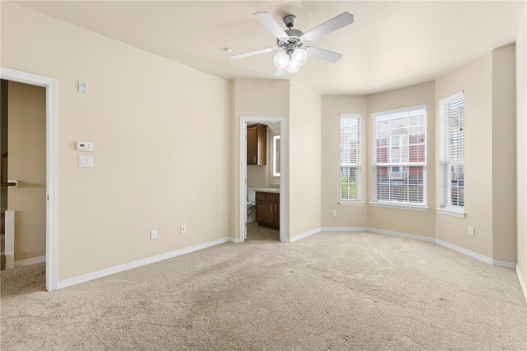 1198 Jones-Butler Road, Unit 705 College Station, TX 77840 - Photo 22 of 34 Unfurnished bedroom featuring light carpet, connected bathroom, and ceiling fan