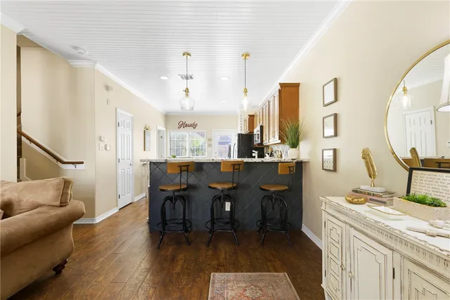 a living room with stainless steel appliances kitchen island granite countertop furniture a rug a fireplace and a kitchen view
