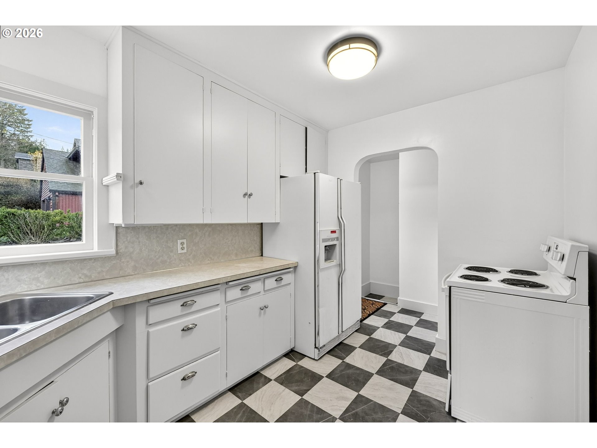 11811 Southwest 34th Avenue Portland, OR 97219 - Photo 11 of 39 a kitchen with a checkered floor and white cabinets