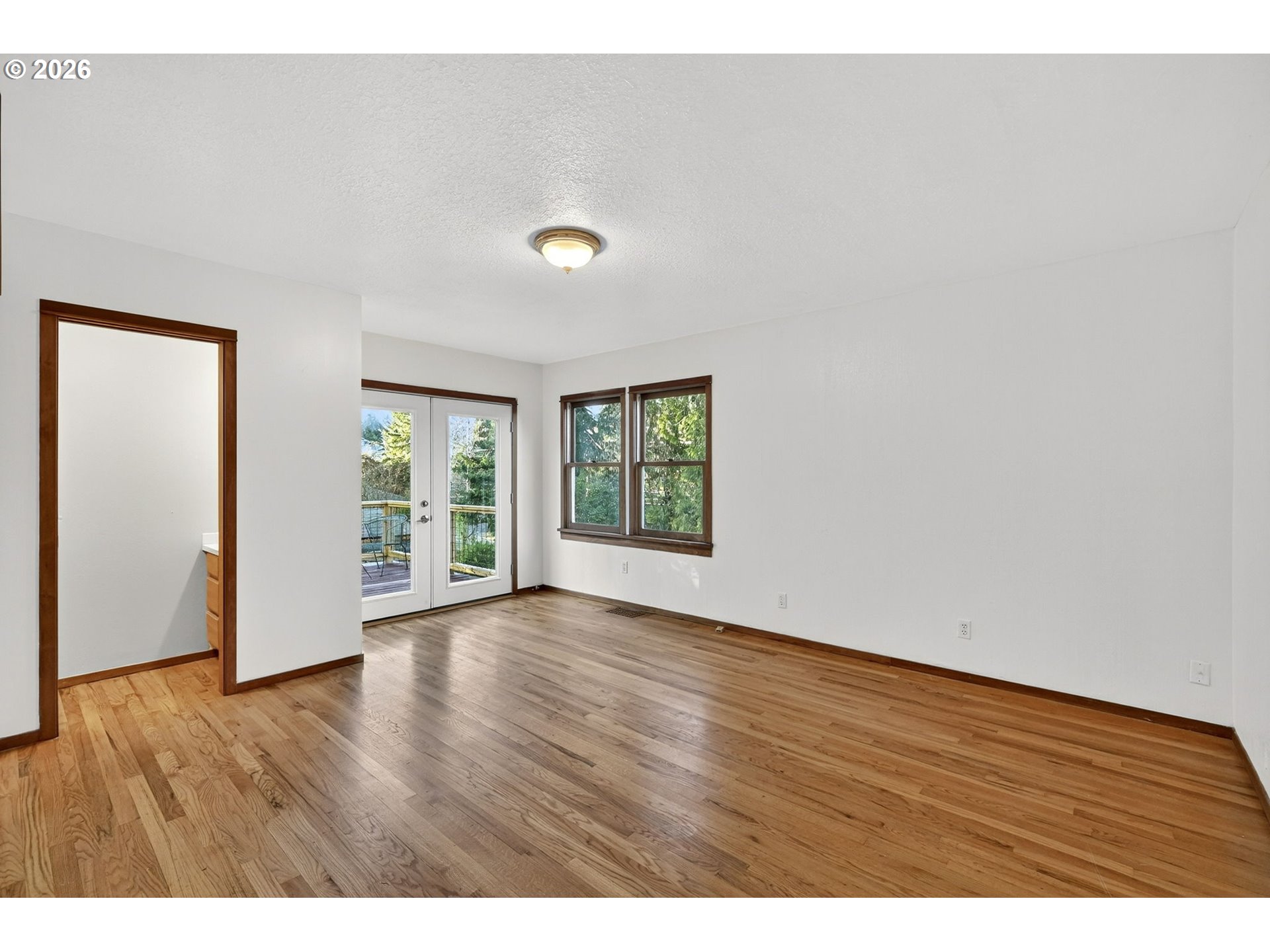 11811 Southwest 34th Avenue Portland, OR 97219 - Photo 13 of 39 a view of an empty room with wooden floor and a window